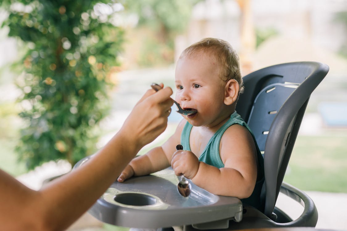 Free Photo Of Baby Eating On A Chair Stock Photo