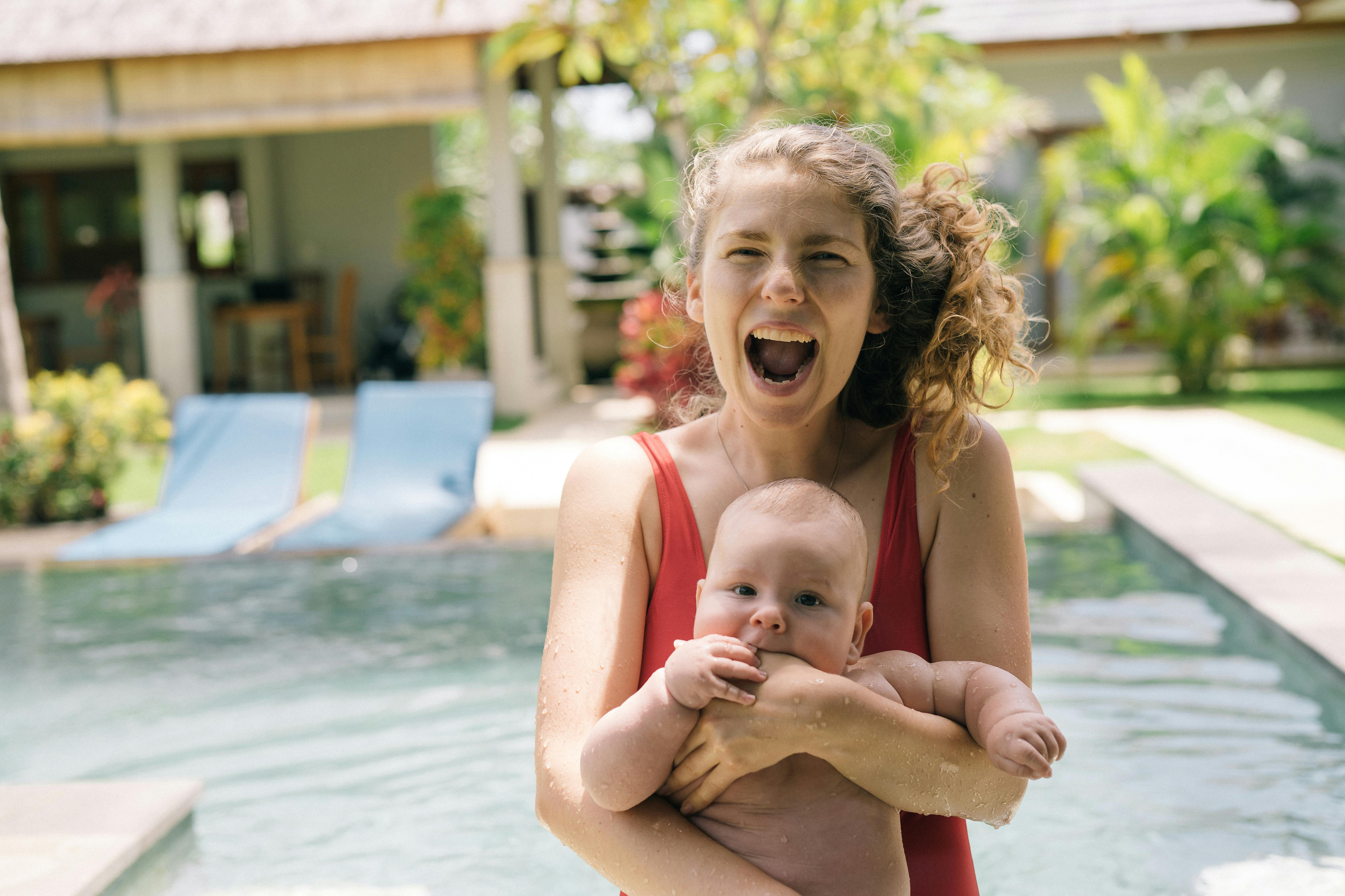 laughing mother carrying her baby