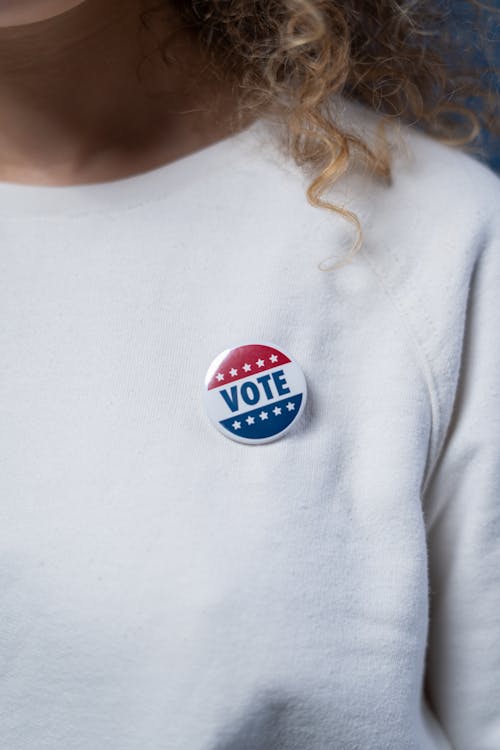 Free Vote Pin on a White Sweater Stock Photo