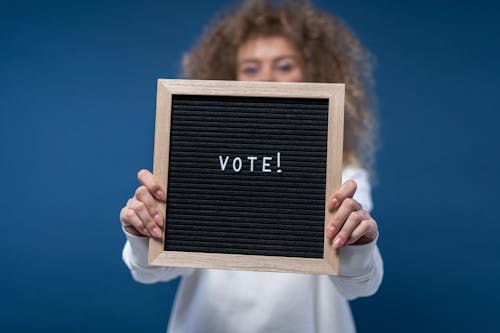 Free Person Holding a Vote Sign Stock Photo