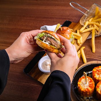 Close-up of a gourmet burger with fries on a wooden table in a Dubai cafe.