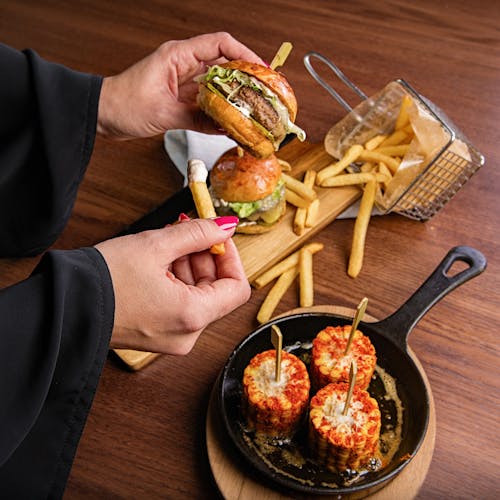 Photo Of Person Holding Burger And Fries