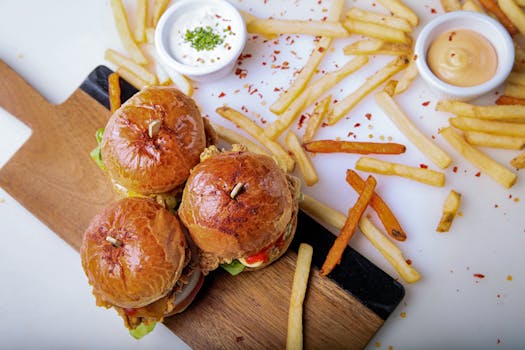 Delicious gourmet burgers with a side of french fries in a cafe setting, perfect for a tasty meal.