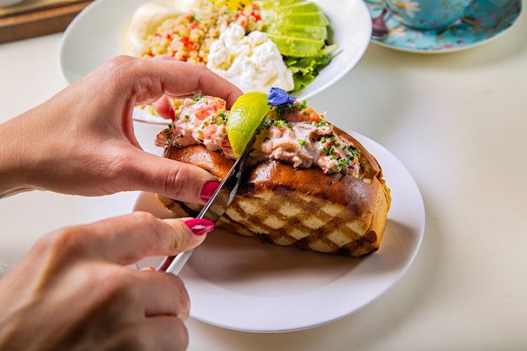 A Person Slicing A Sandwich