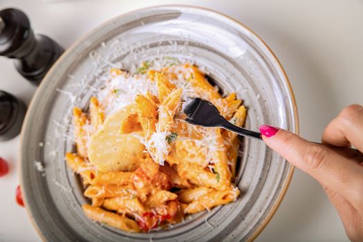 Close-up of creamy penne pasta with Parmesan cheese, highlighting delicious Italian cuisine.