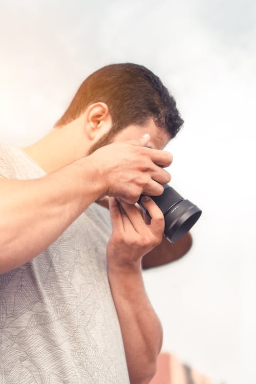 A Man in Gray Shirt Taking Photo with a Camera