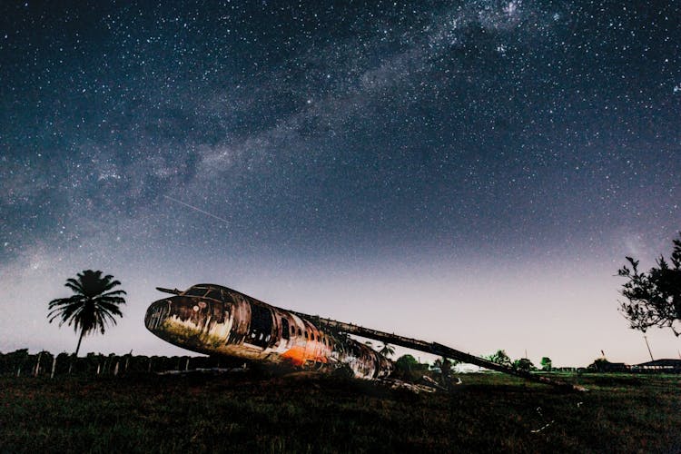 Crashed Airplane On Land Under Bright Sky In Evening