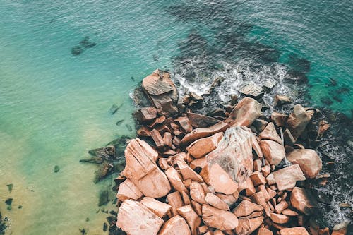 Rough rocks in waving ocean water in daylight