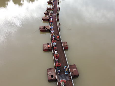 Aerial shot of a crowded floating market bridge with motorbikes transporting goods in Vietnam.