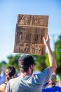Anonymous protesters with placard during strike on street