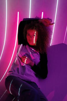 Artistic portrait of a person with curly hair under neon light projections, creating a modern and futuristic vibe.
