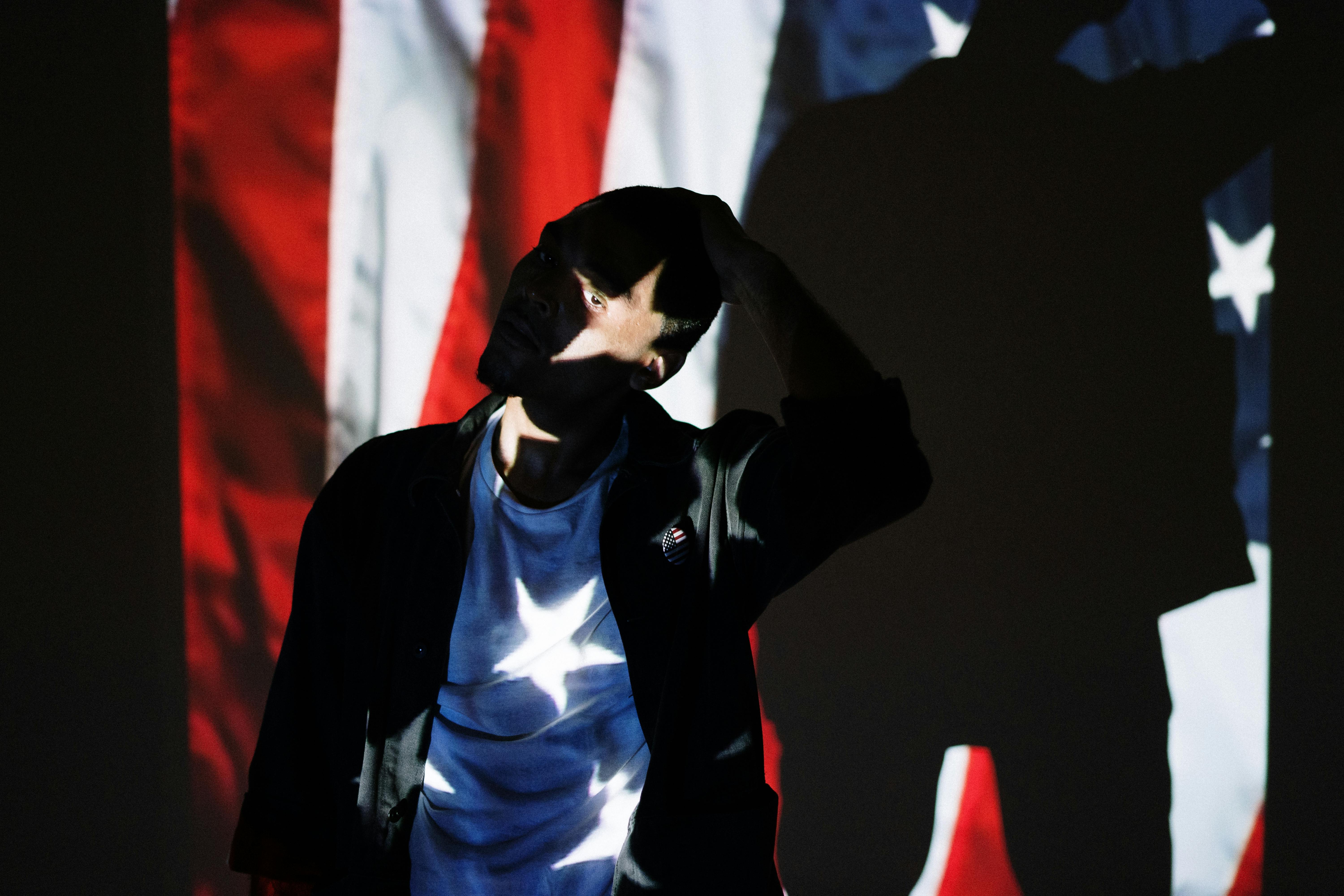 man in front of a projection of the american flag