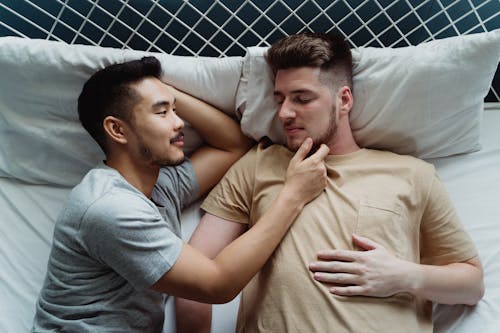 Free Two Men Lying Down Together in Bed Stock Photo