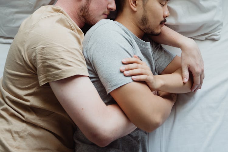 Two Men Cuddling In Bed