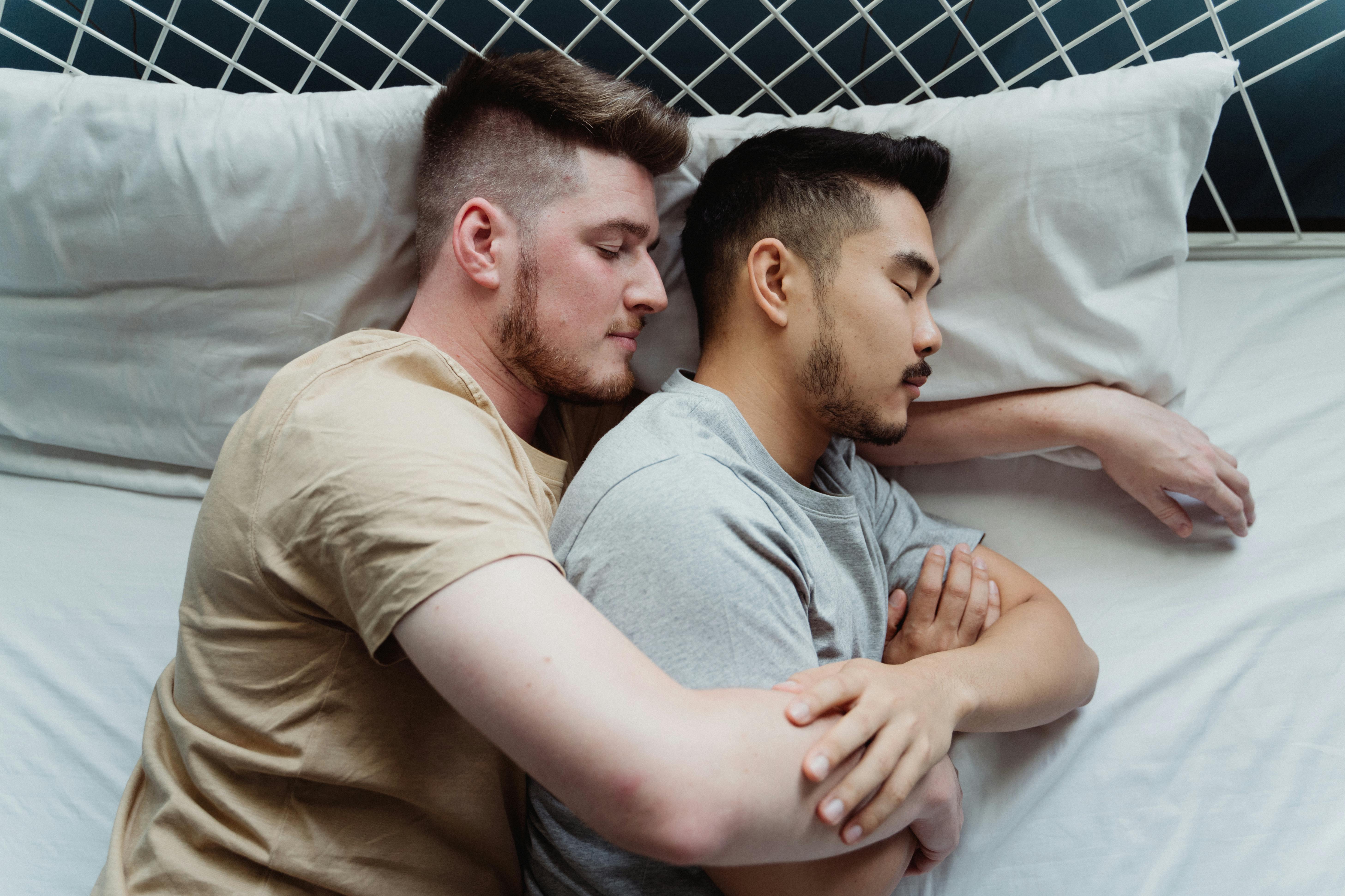 Two Men in Bed Holding Hands · Free Stock Photo