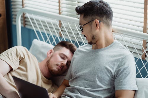 Free Man Seeing Another Man Sleeping in Bed Stock Photo