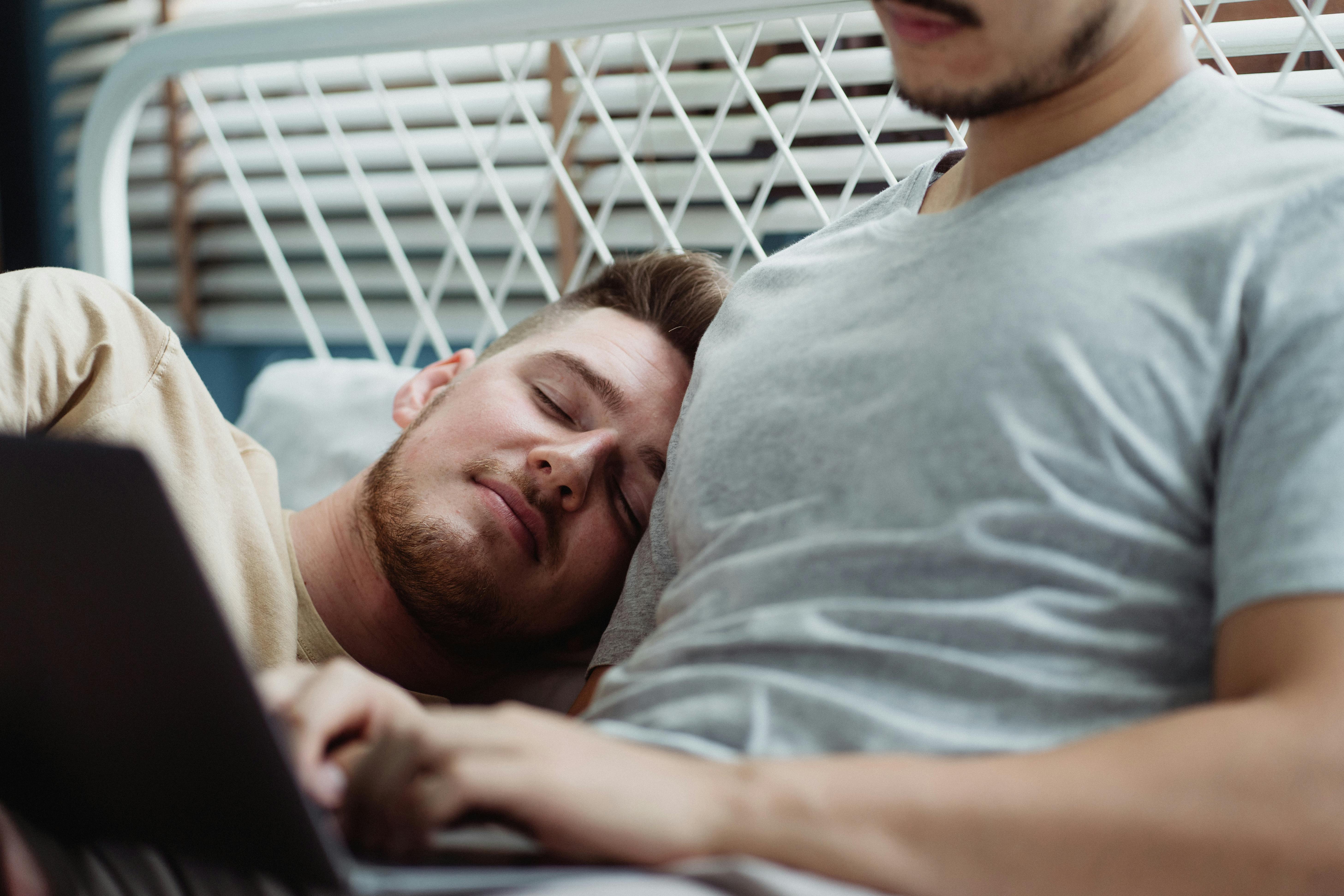 sleeping man cuddling against another man