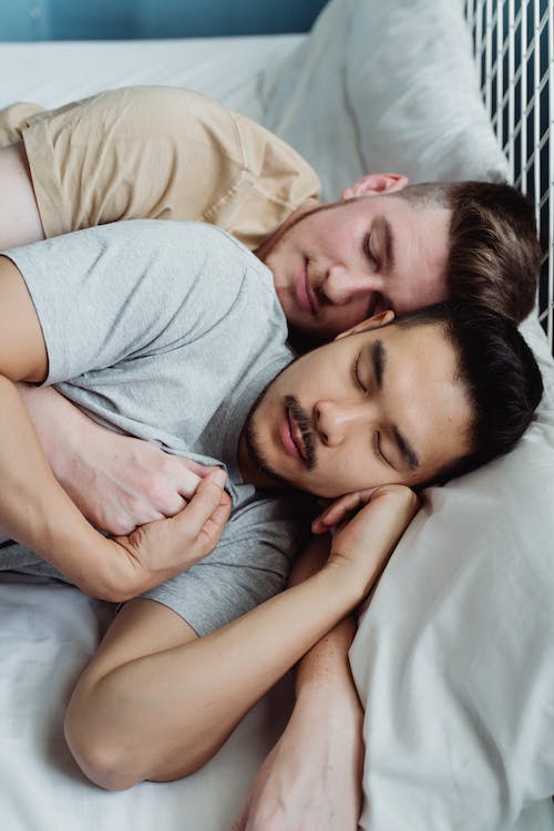 Free Two Men in Bed Holding Hands Stock Photo