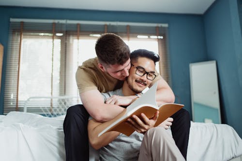 Free Man Reading and Being Embraced by Another Man Stock Photo