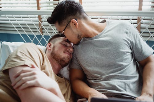 Free Man Kissing Another Man on the Forehead Stock Photo