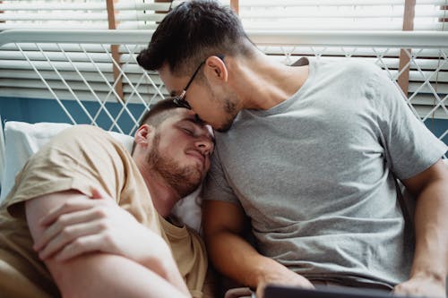 Man Kissing Another Man on the Forehead