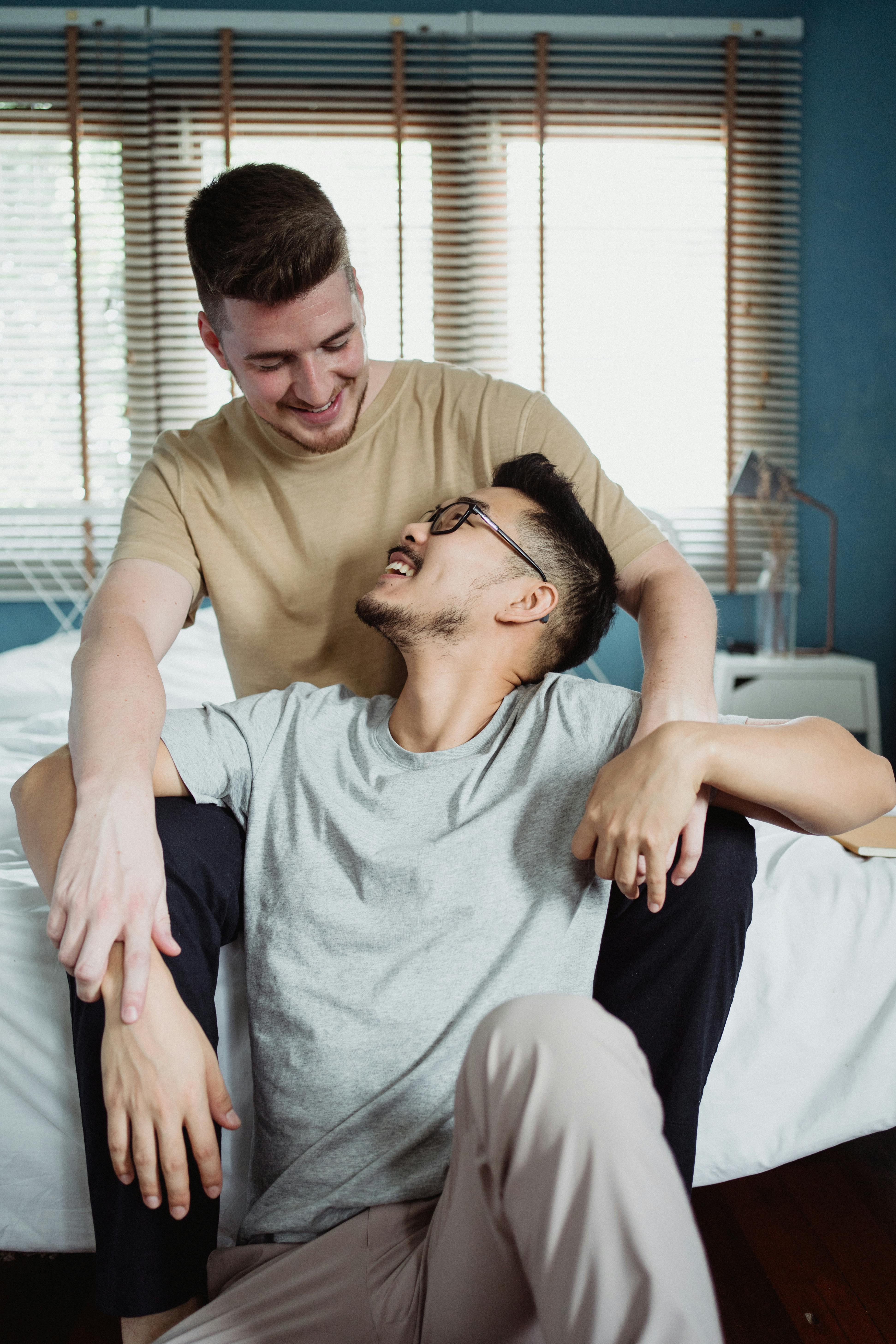 two men holding hands and looking at each other