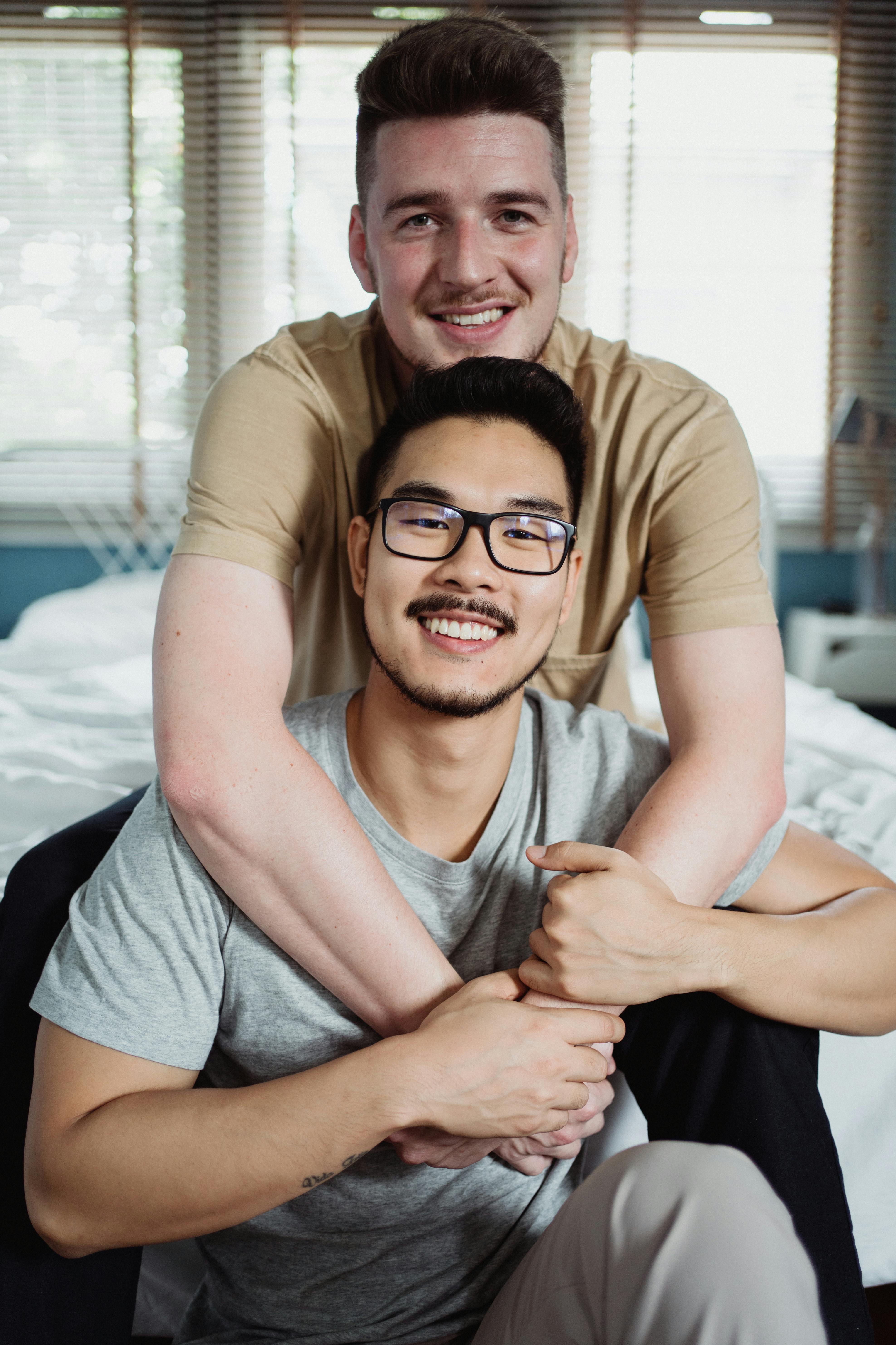 two men being affectionate and looking at the camera