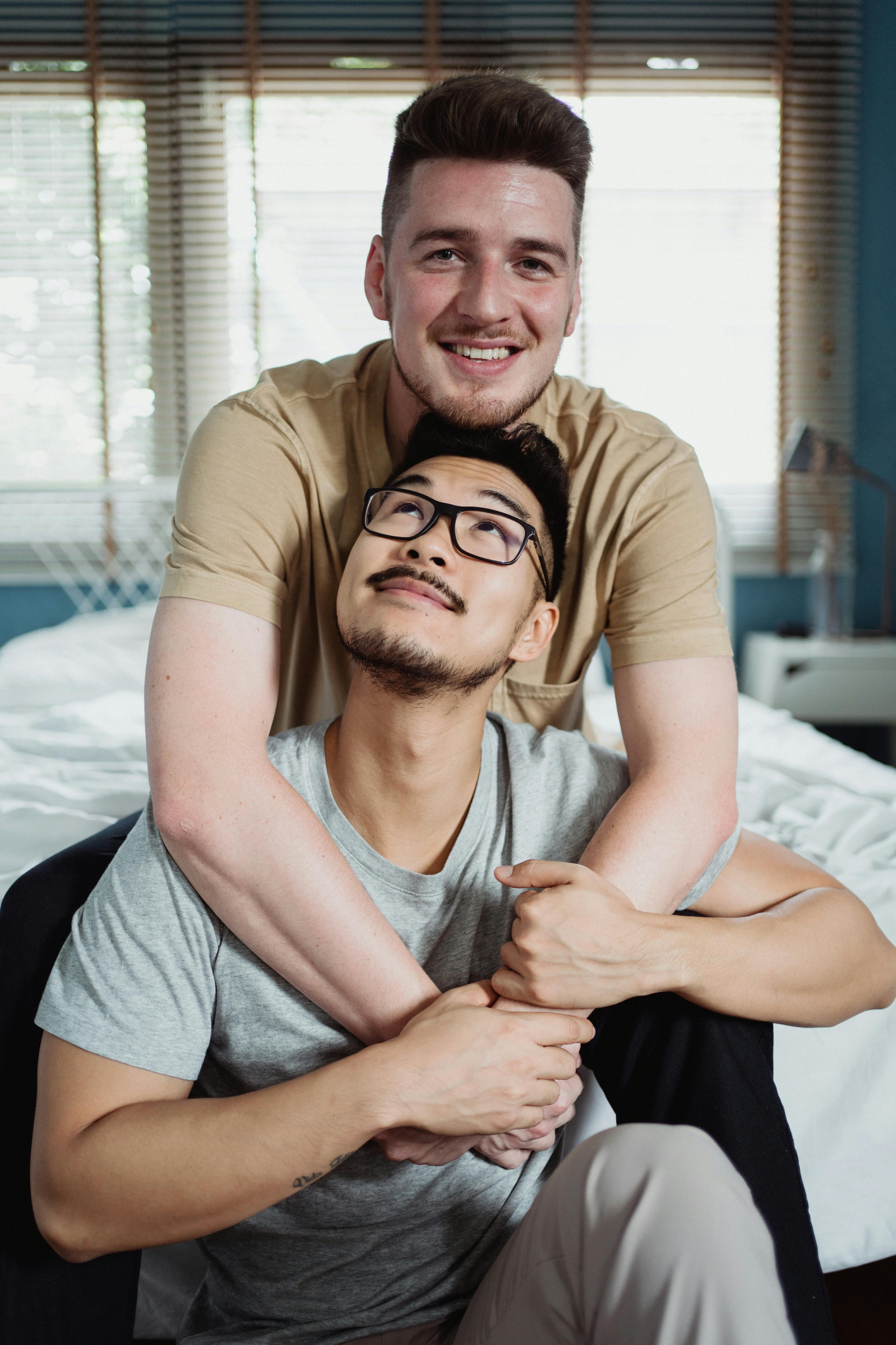 man embracing another man from behind