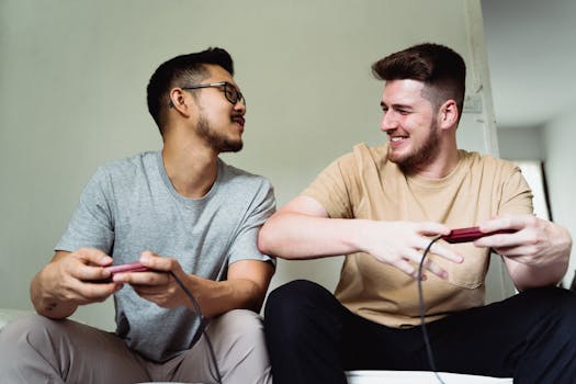 Two cheerful men playing video games together indoors, sharing a joyful moment.