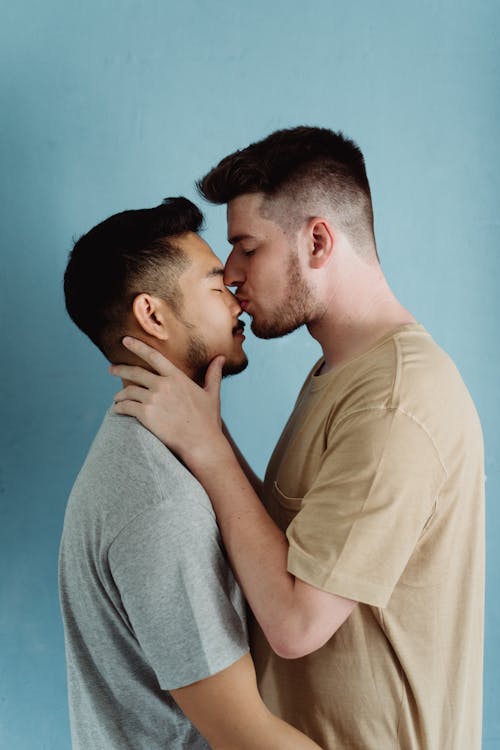 Free Man Kissing Another Man on the Nose Stock Photo