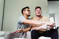 两个朋友在舒适的客厅里一起笑着玩电子游戏