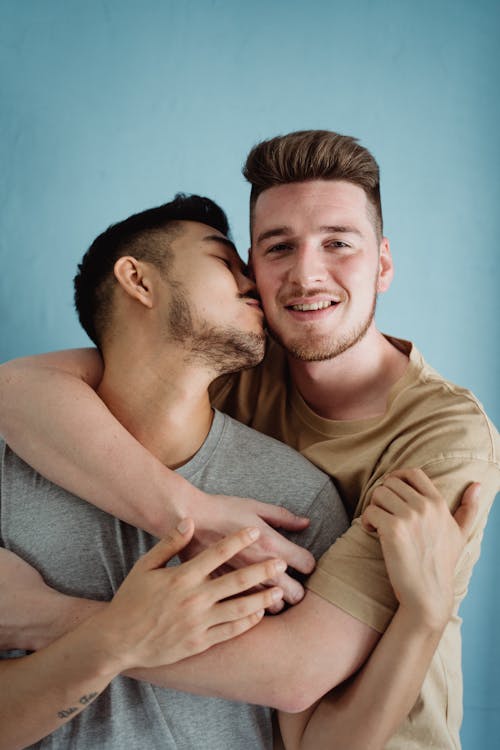 Man Kissing Another Man on the Cheek