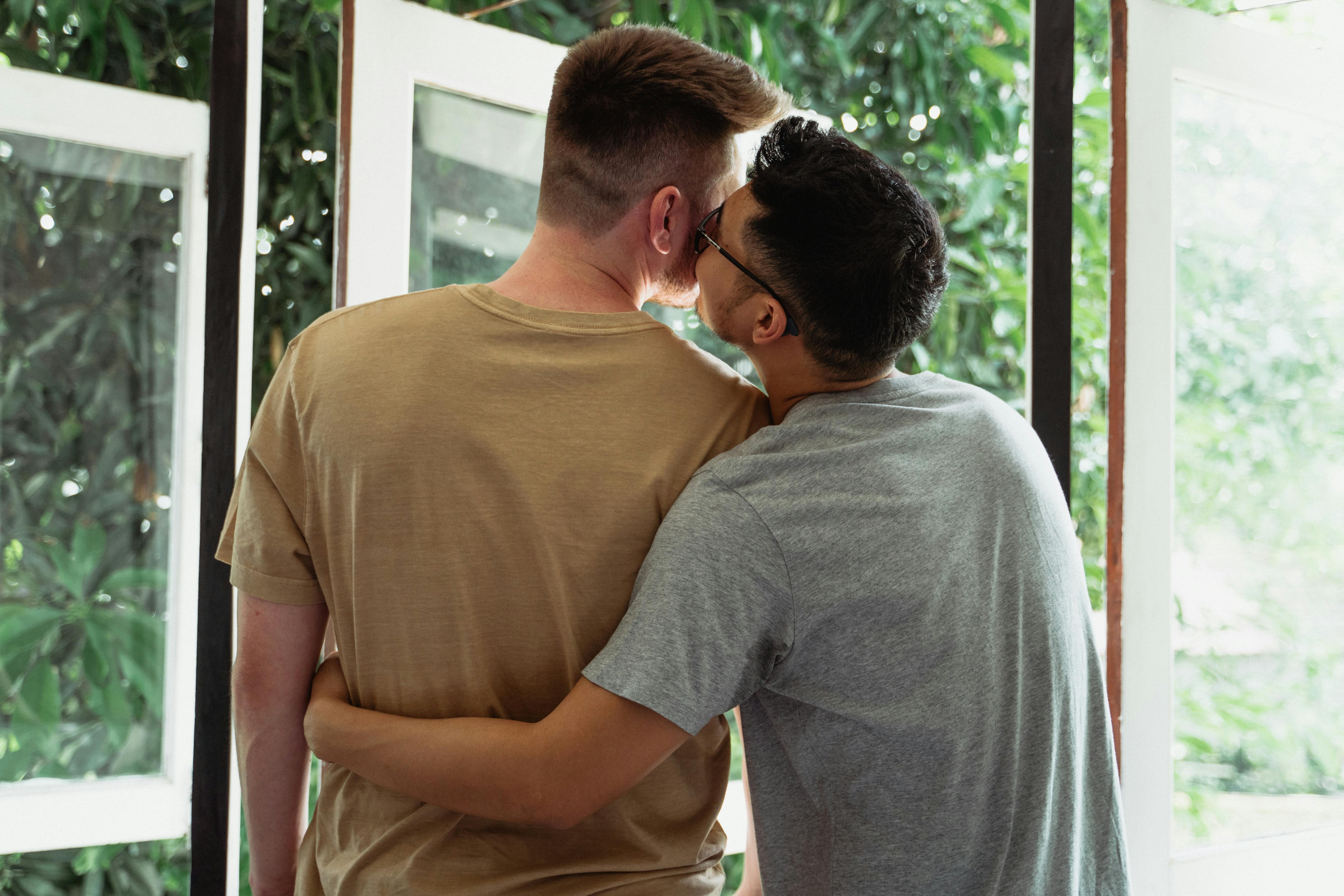 man kissing another man on the cheek