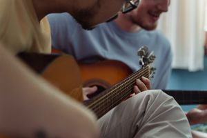 Two people playing acoustic guitars indoors. Photo by Ketut Subiyanto on Pexels