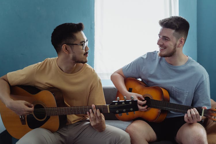 Men Playing Guitars Together