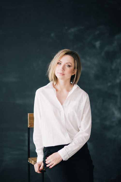 Free Stylish portrait of a blonde woman in a white shirt sitting on a chair, exuding elegance. Stock Photo