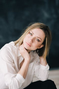 一位金发女子以宁静的姿势，在柔和的背景下摆出迷人的肖像