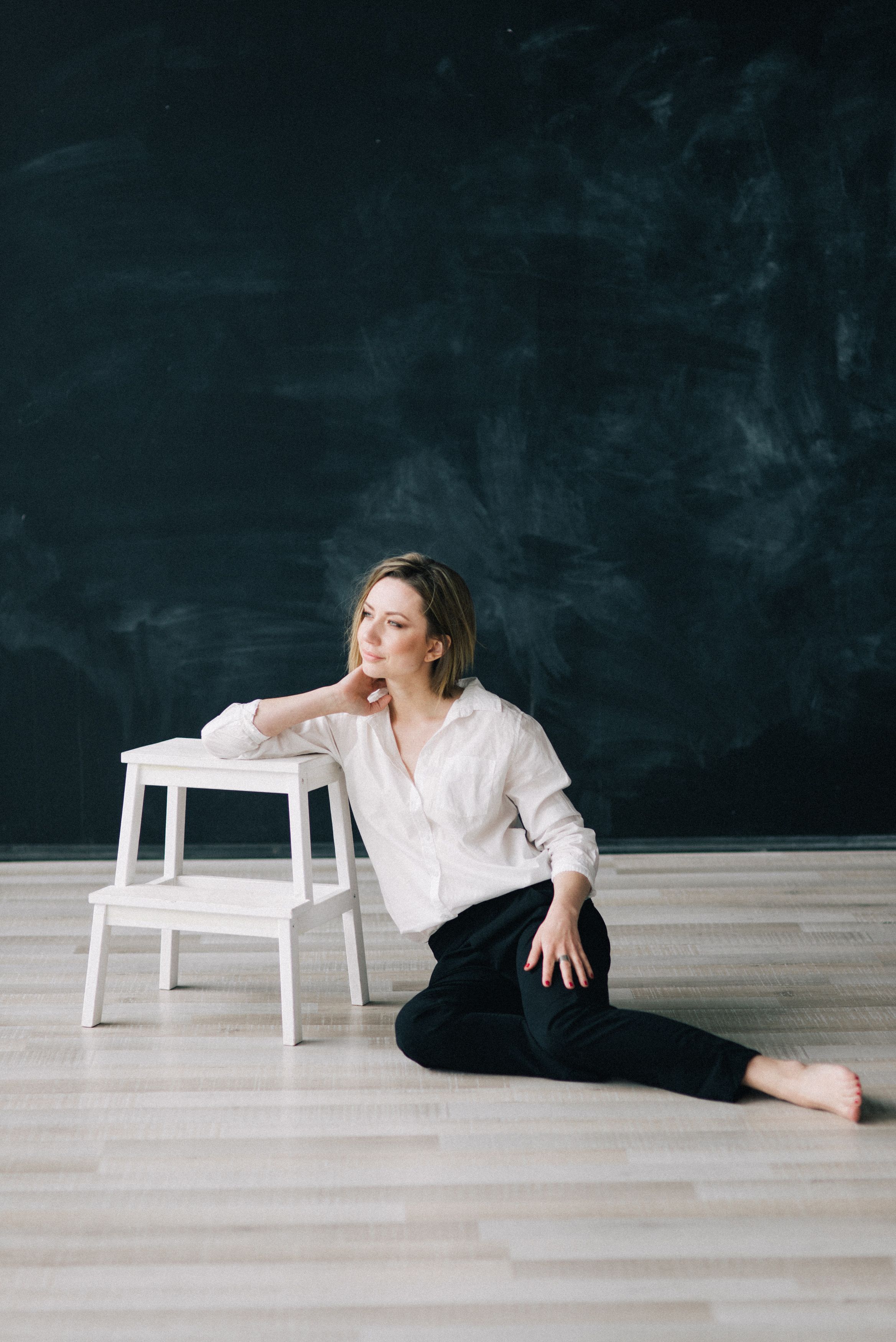 Woman in Black Long Sleeve Shirt Leaning on White Wall · Free Stock Photo