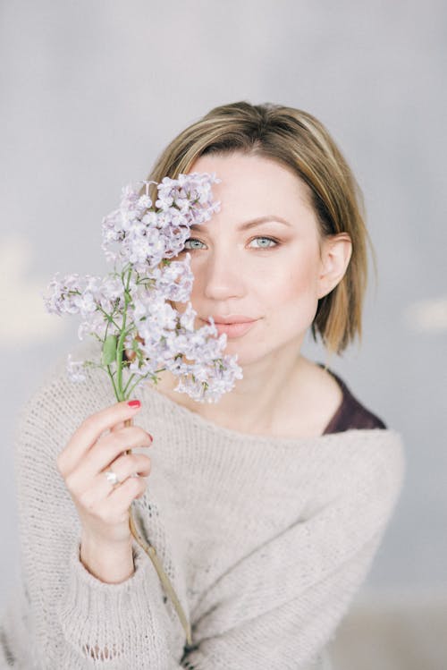 Woman Holding a Stem with Flowers