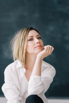 一位穿着白衬衫的白人妇女在室内优雅地摆着姿势，肖像中她表情若有所思