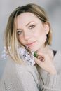 Beautiful Woman Smiling with Lilac Flowers near her Face