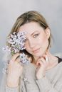 Woman Holding Small Flowers near to her Face