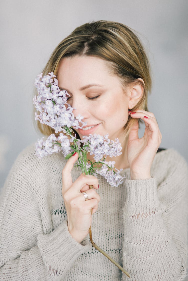 Gorgeous Female Holding Lilac Flowers While Touching Her Hair