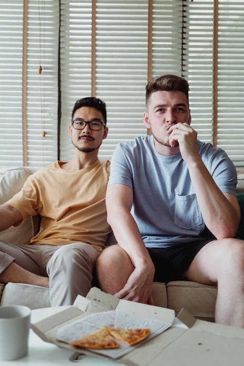 Men Sitting Beside Each Other on a Couch