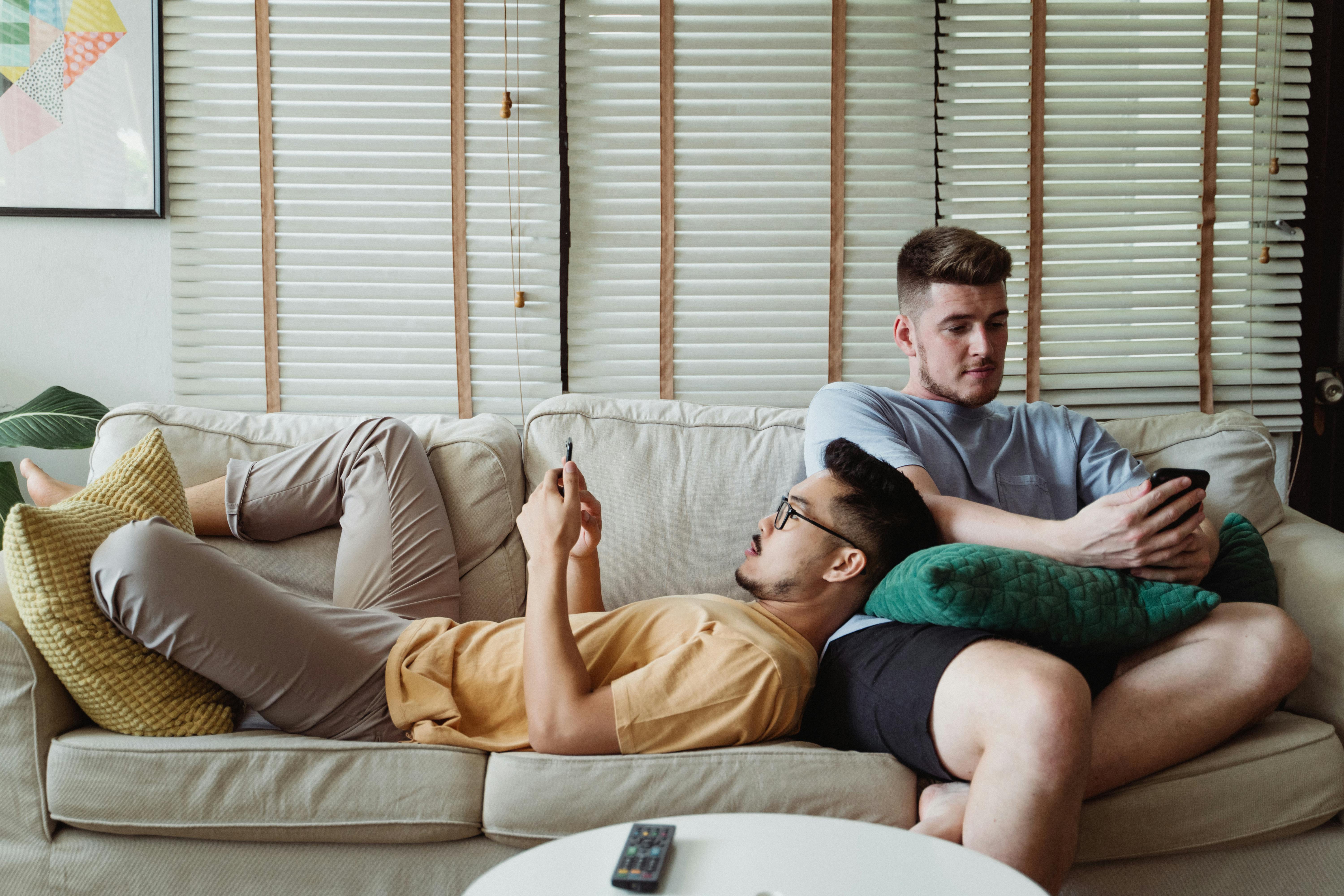 two men relaxing on a couch