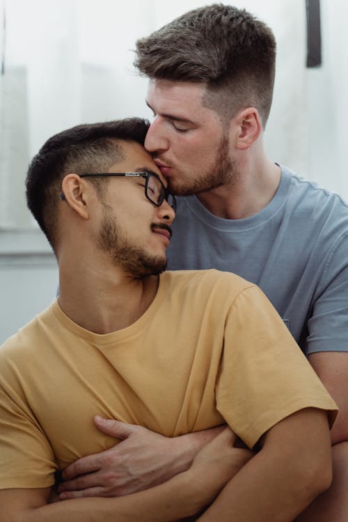 Free Man Kissing Another Man on the Forehead Stock Photo