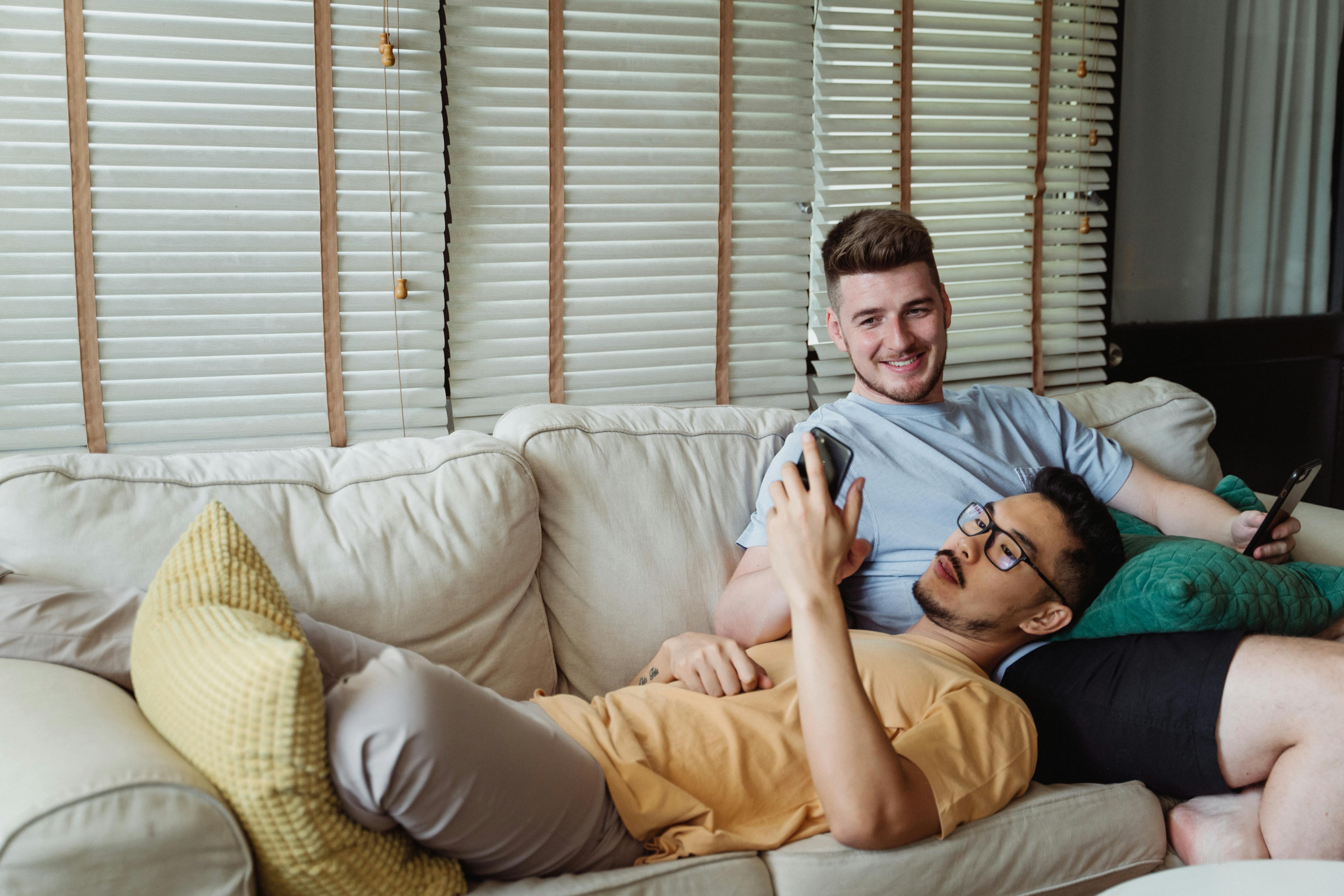 two men relaxing on a couch