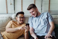 一对夫妇在室内看着智能手机，笑着分享快乐的时刻