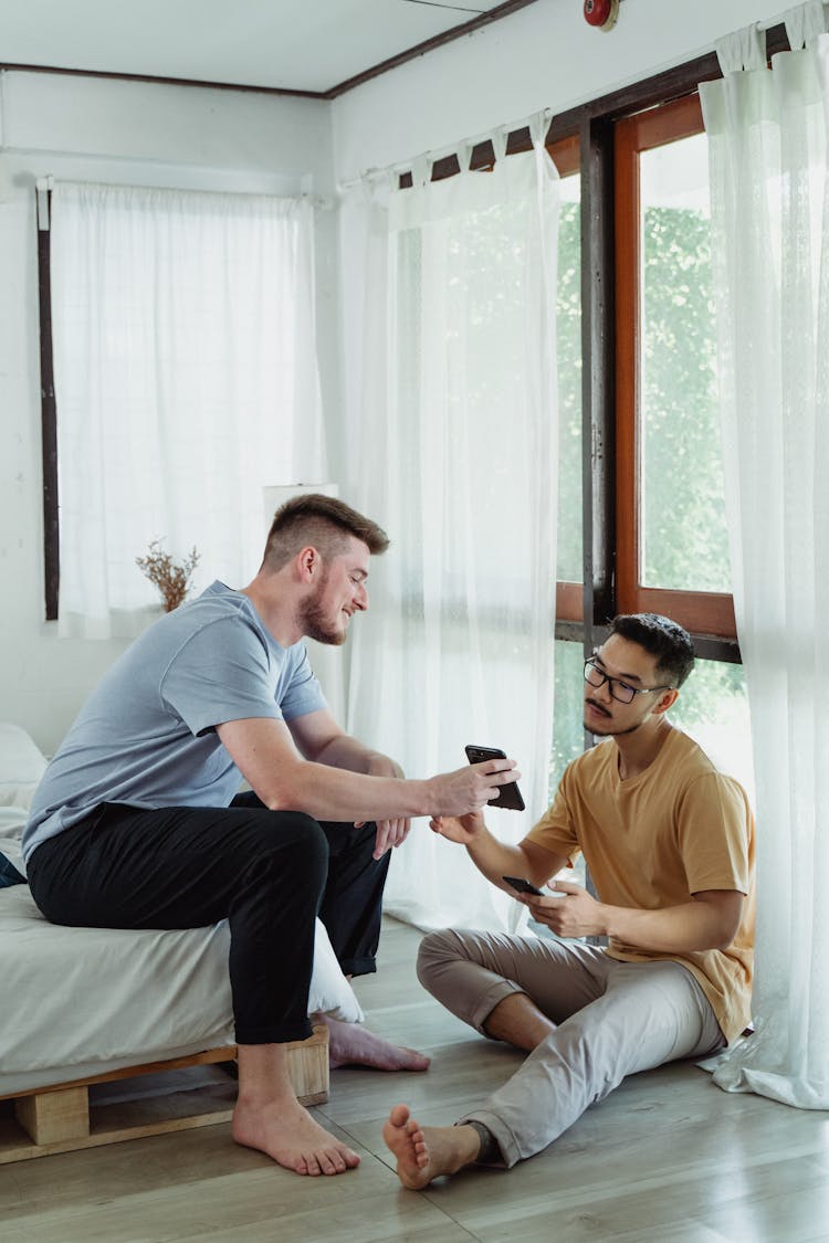 Man Showing His Cellphone To The Person With Eyeglasses