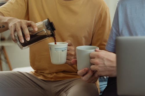 Men Pouring Coffee to Mugs